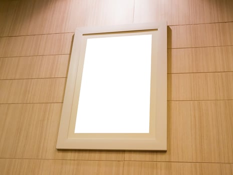 empty photo frame with light and wood wall