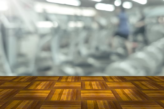 Empty wooden board space platform with blur fitness gym equipment background photo