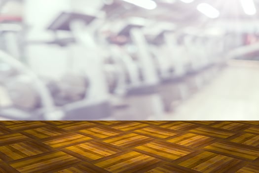 Empty wooden board space platform with blur fitness gym equipment background photo