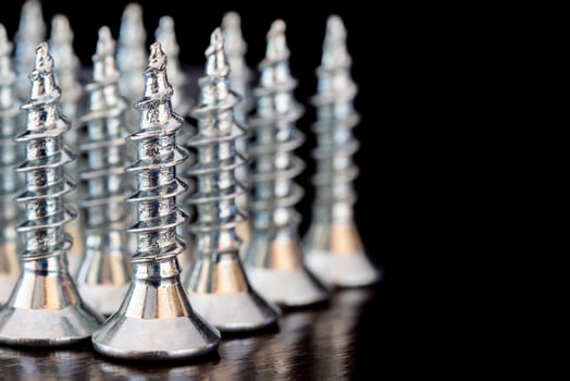 Close up of screws on a black background. Advertising photo. Selective focus photo