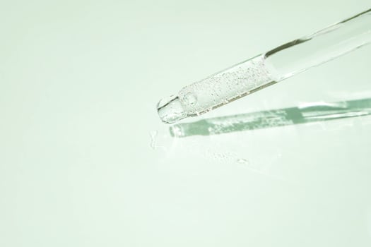 Close-up pipette with a hyaluronic moisturizing serum on a green background. Beauty skin care concept Beauty and spa. photo