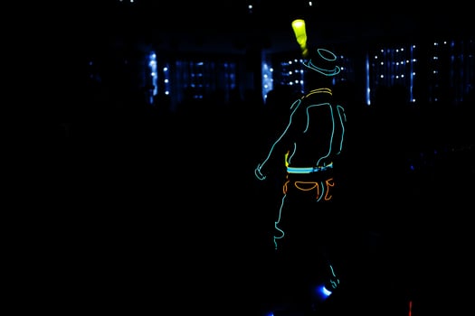 Professional barman and led light show. Silhouette of modern bartender shaking drink at night cocktail bar. photo
