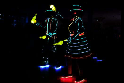 Professional barman and led light show. Silhouette of modern bartender shaking drink at night cocktail bar. photo