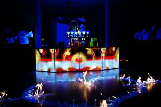 Professional barman and led light fire show. Silhouette of modern bartender shaking drink at night cocktail bar. photo
