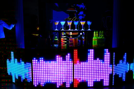 Professional barman and led light show. Silhouette of modern bartender shaking drink at night cocktail bar. photo