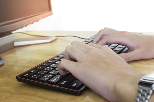 Close up of typing male hands on black keyboard,Businessman working concept,light effect photo