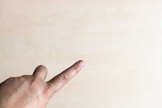 forefinger close up over light brown wooden board photo