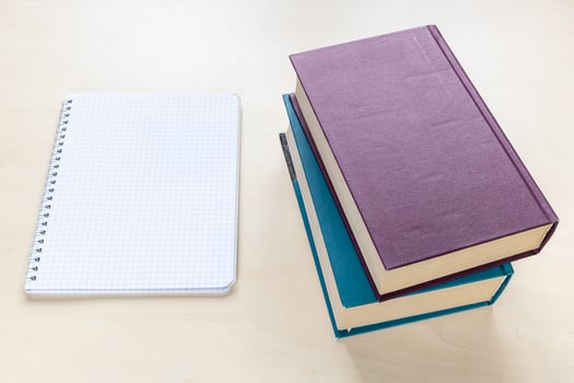 two thick books and blank spiral notebook photo