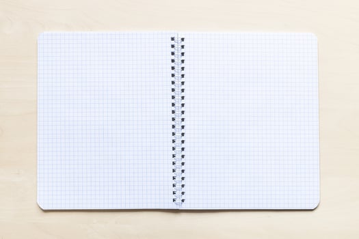 open blank spiral notebook on light brown board photo