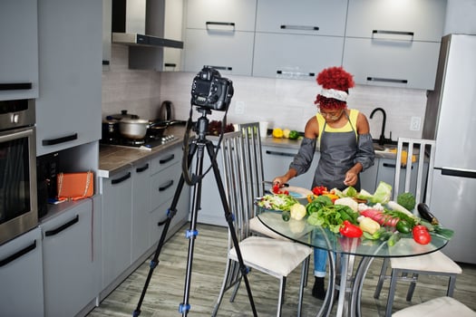 African american woman filming her blog broadcast about healthy food at home kitchen. photo