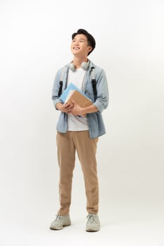 Confident student. Studio portrait of handsome young man holding books. Isolated on white. photo