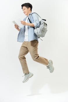 Full length portrait of a funny cheerful male student jumping on white background photo
