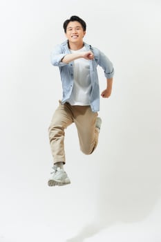 Young handsome Asian man smiling and jumping in mid-air photo