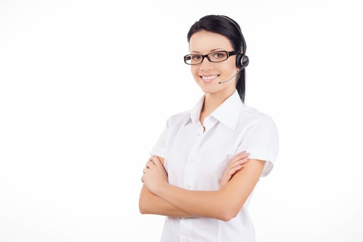 Customer service representative. Confident young woman in headset smiling and keeping her arms crossed while standing isolated on white photo
