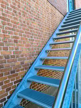 Close up view on metallic stairs in front of a brick wall. photo