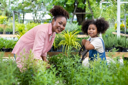 African mother and daughter is choosing vegetable and herb plant from the local garden center nursery with shopping cart full of summer plant for weekend gardening and outdoor concept photo