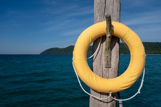 luxury classic Safety Torus covered by yellow cloth. It hangs on to old wooden pole settle on the jetty in the sea. photo