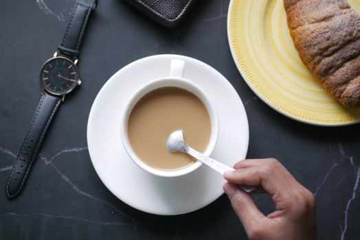 person hand stirring coffee with spoon. photo