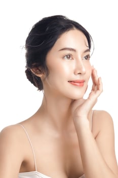 Asian woman with a beautiful face and Perfect clean fresh skin. Cute female model with natural makeup and sparkling eyes on white isolated background. Facial treatment, Cosmetology, beauty Concept. photo