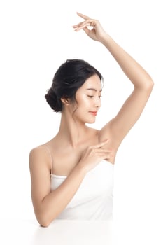 Asian woman with a beautiful face and Perfect clean fresh skin. Cute female model rising arm show her armpit on white isolated background. Facial treatment, Cosmetology, beauty Concept. photo