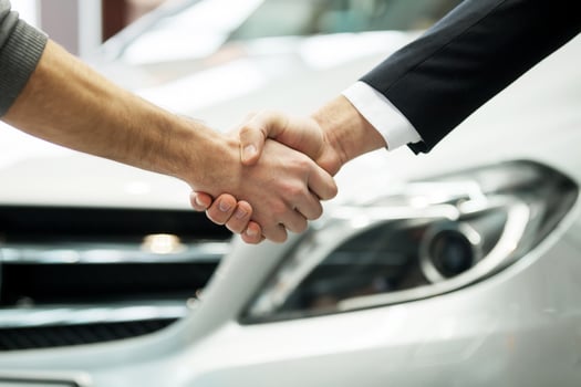Good deal. Close-up shoot of the hands shaking in front of the car photo