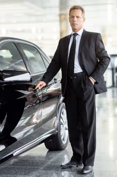 I choose this car. Full length of mature grey hair businessman standing near car and holding the door handle at the dealership photo