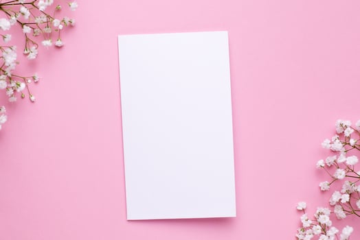 Present card with white flowers on pink pastel table top view and flat lay style. Fashion summer color. photo