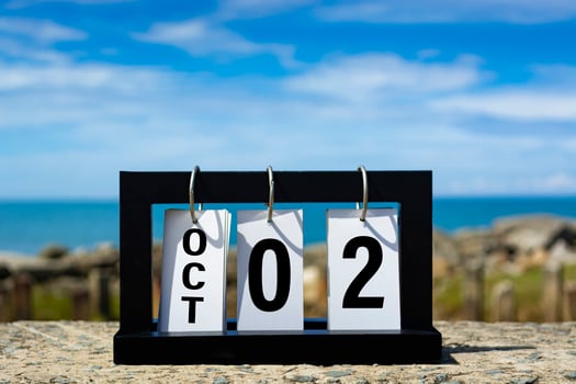 Oct 02 calendar date text on wooden frame with blurred background of ocean. photo