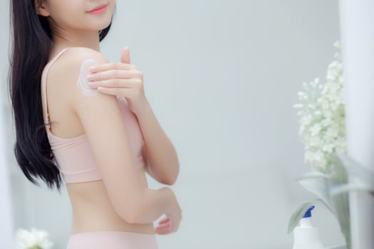 Beautiful sexy young asian woman look mirror applying cream on shoulder and message, beauty girl applying body lotion skin care for health and soft hydration, treatment and cosmetic with moisturizer. photo