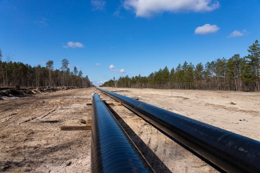 Crude oil and Natural gas pipeline construction work in forest area. Petrochemical Pipe on top of wooden supports. Installation and Construction the Pipeline for transport gas to LNG plant photo