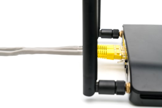 Black wireless router with local area network cable isolated on white background photo