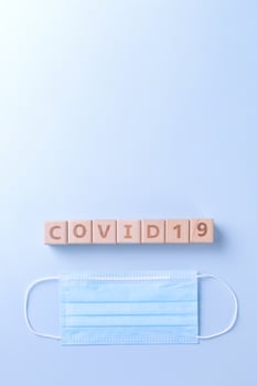 COVID-19 word wooden cube with mask, medical equipment, world disease pandemic infection and prevention concept, top view, flat lay, overhead design photo