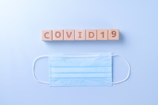 COVID-19 word wooden cube with mask, medical equipment, world disease pandemic infection and prevention concept, top view, flat lay, overhead design photo