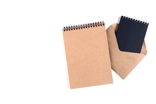 Blank spiral notepads and a recycled envelope photo