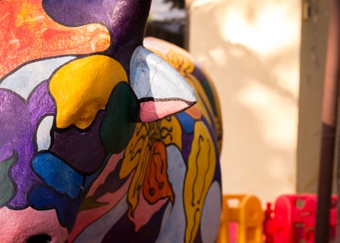 Various colored buffalo sculptures and wall background photo