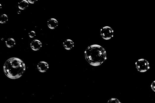 Flying soap bubbles isolated on a black background. Abstract background. photo