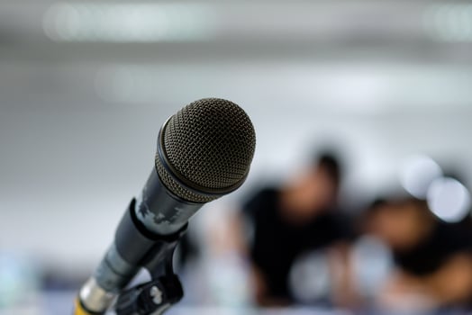 Microphone on the abstract blurred photo of seminar room background