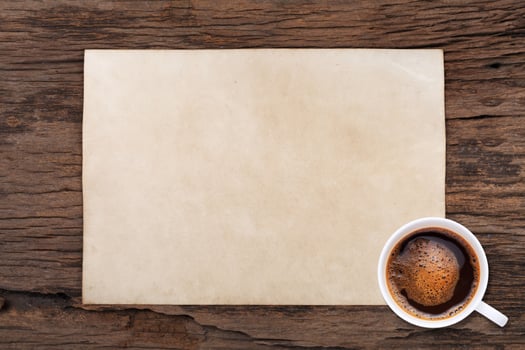 Old blank paper and a cup of coffee on wooden photo