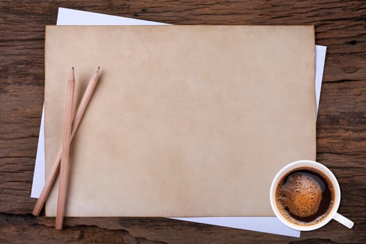 blank paper with pencil and a cup of coffee on wooden photo