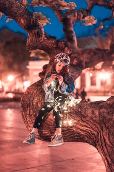 preschool girl sitting on a tree branch photo