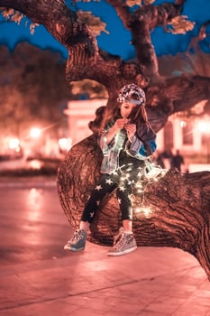 preschool girl sitting on a tree branch photo