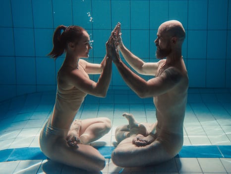 underwater portrait of the athletic, sporty dancing and doing yoga asanas couple man and woman underwater in the swimming pool photo