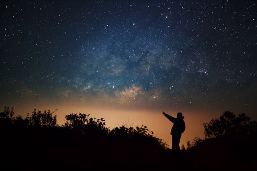 A Man is standing next to the milky way galaxy pointing on a bright star at Doi Luang Chiang Dao high mountain in Chiang Mai Province, Thailand. photo