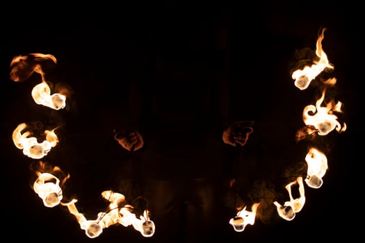 Fireshow in dark. Two steel fans with hot flames. photo