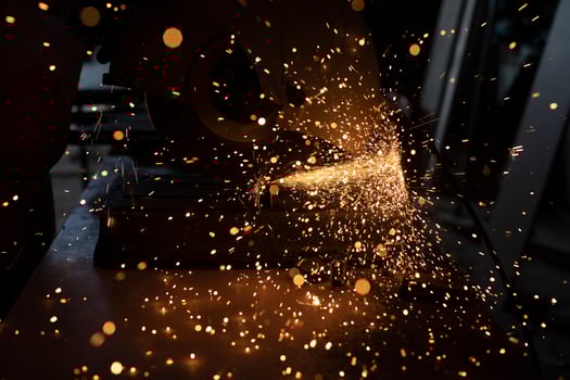 Sparks from grinder. Metal cutting. Bright lights in dark. Industrial background. photo