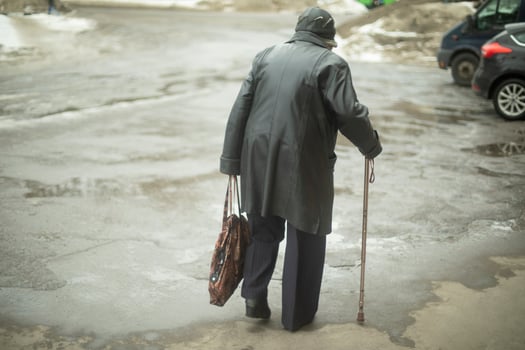 Woman with pore stick walks down street while walking. Pensioner in Russia. photo