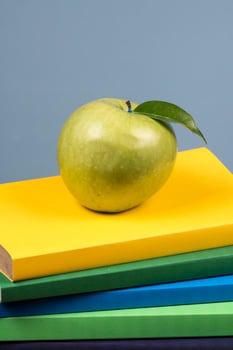 Apple fruit on top of a book stack, on the back of school classes. photo