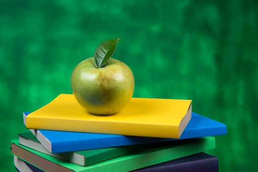 Apple fruit on top of a book stack, on the back of school classes. photo