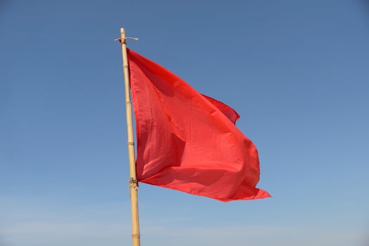 red flag swaying in the wind on a blue sky background photo