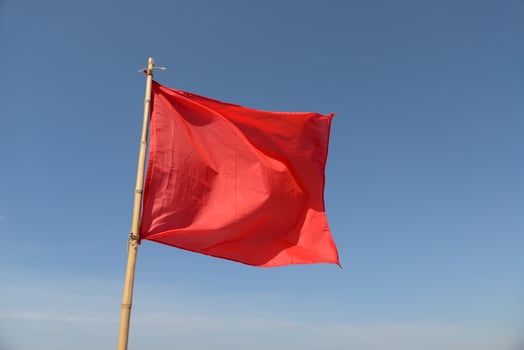 red flag swaying in the wind on a blue sky background photo